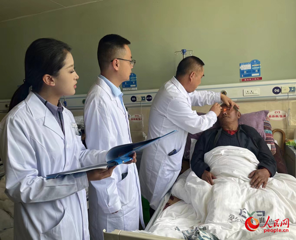 董光明（左三）帶領醫生對患者進行術前檢查。人民網記者 杜燕飛攝