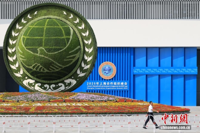 8月31日，天津，一名工作人員從2025年上海合作組織峰會主會場外的景觀花壇旁經過。當日，2025年上海合作組織峰會在天津舉行。<a target='_blank' href='/'><p  align=