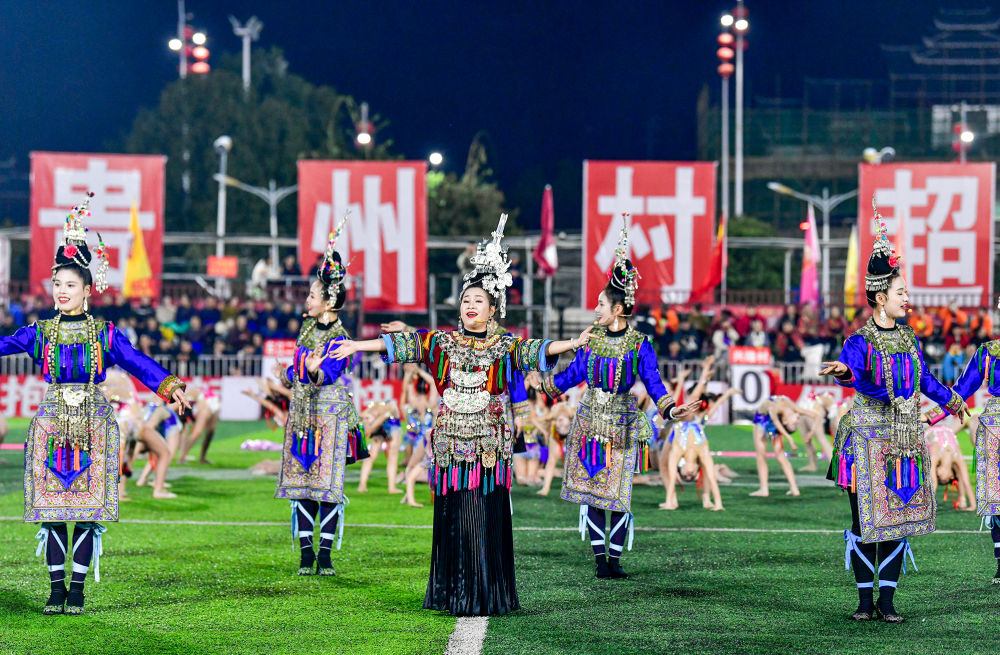 2025年3月14日，2025年貴州“村超”40強(qiáng)交叉賽在榕江“村超”足球場(chǎng)舉行，演員在比賽間隙表演侗族大歌，民族文化伴隨著體育賽事成功“出圈”。圖片來源：新華社